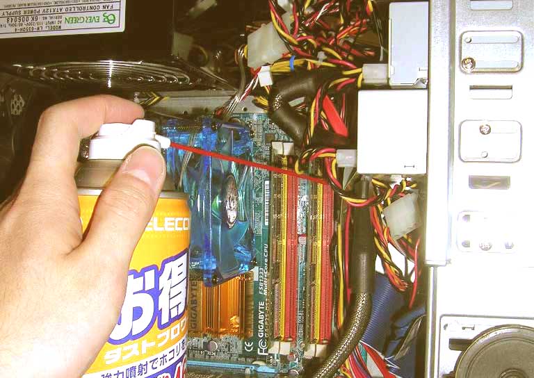 air duster is being used to clean a computer CPU.